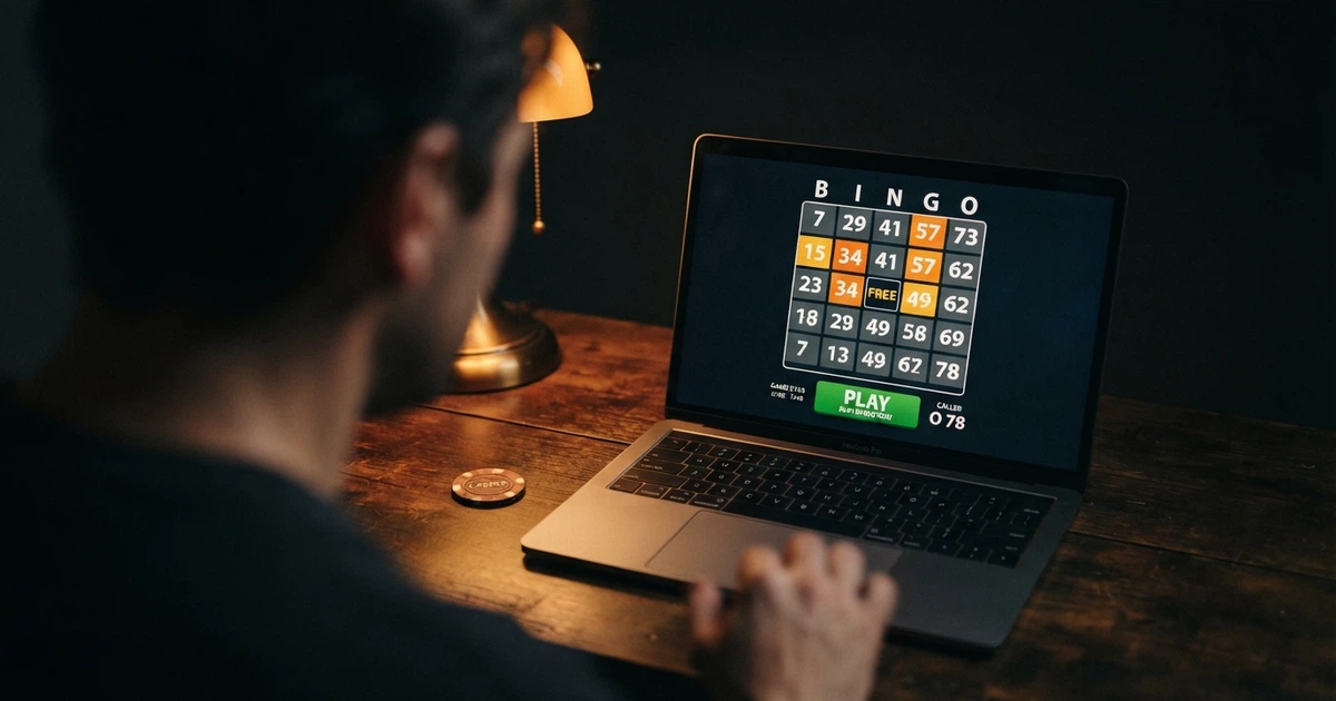 Plansza do bingo z zaznaczonymi numerami na ekranie komputera, obok karty do gry i przycisk „zagraj” w interfejsie kasyna online